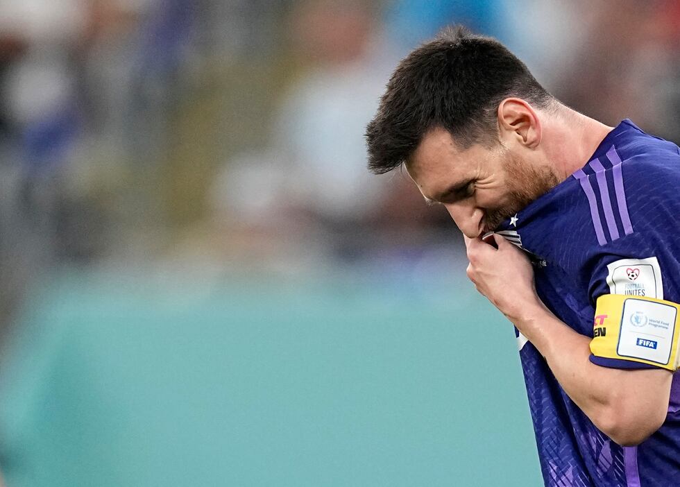 El delantero argentino Lionel Messi se seca el sudor durante el partido contra Polonia por el...
