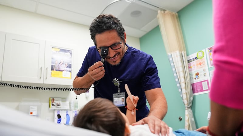 ARCHIVO - El pediatra Irving Phillips examina a un niño de 16 meses en una clínica de...