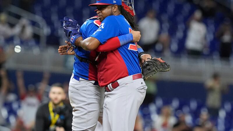 Jairo Asencio, lanzador de República Dominicana, abraza al receptor Webster Rivas tras la...