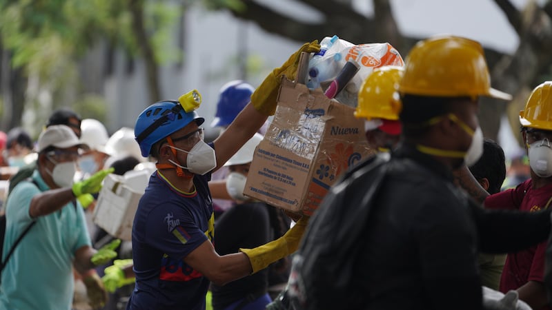 Los rescatistas distribuyen paquetes de alimentos a los equipos de rescate y voluntarios que...