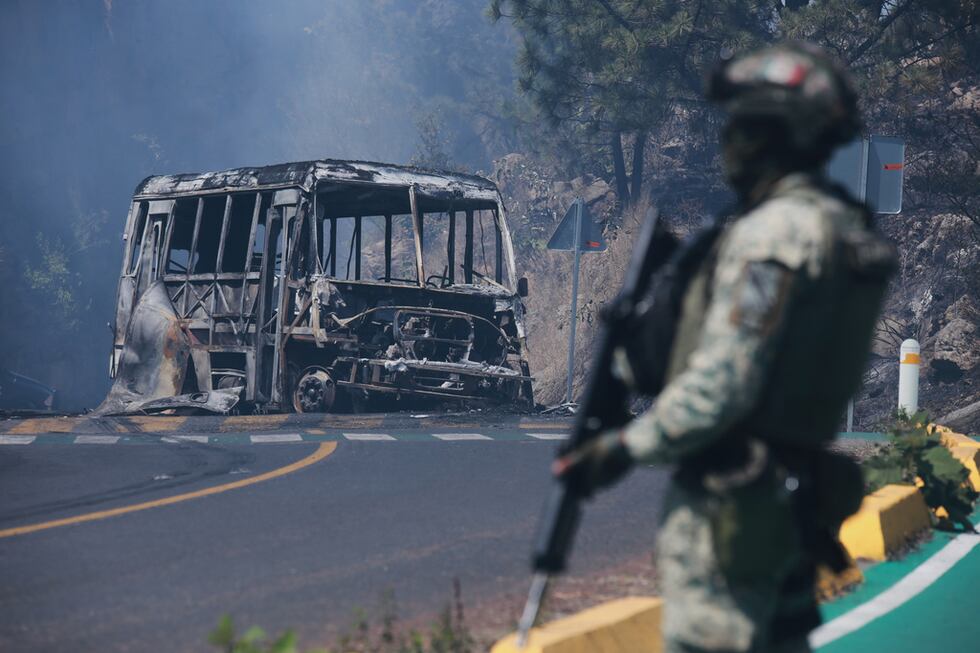 Un soldado monta guardia ante un vehículo calcinado en Cointzio, estado mexicano de Michoacán,...