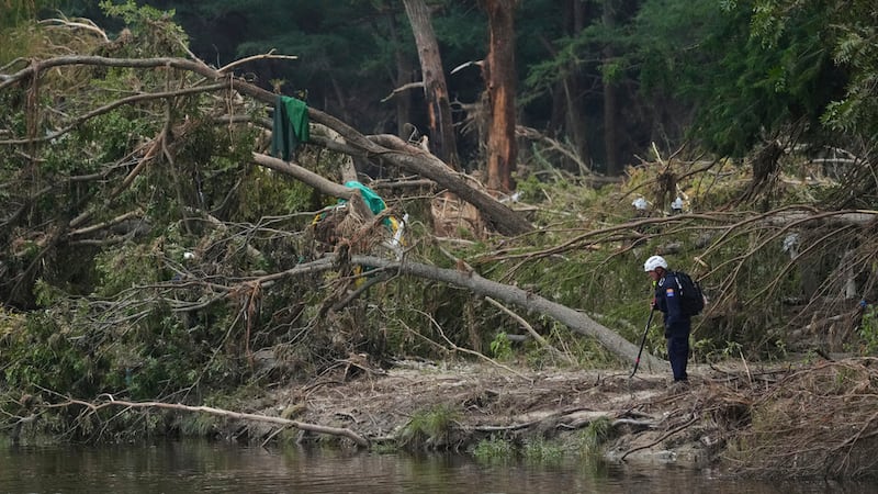 Equipos de emergencia buscan a víctimas de las inundaciones, a orillas del río Guadalupe en...