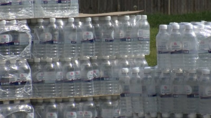 First responders and volunteers give out cases of bottled water as Colonial Heights boil water...