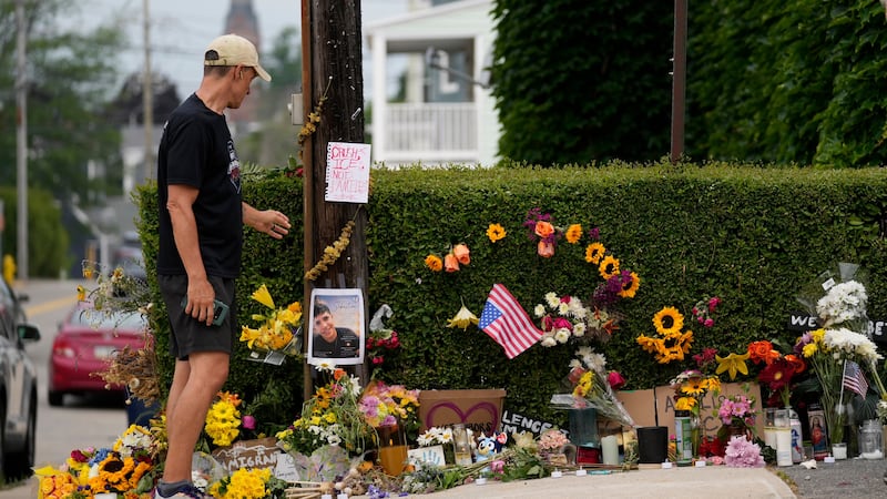 A man pauses to view a makeshift memorial to the victim of a shooting involving U.S....