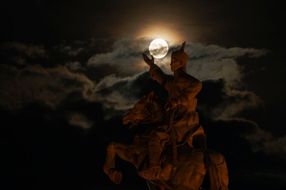 La superluna detrás de la estatua de Damdin Sujbaatar, en la Plaza Sujbaatar, de Ulán Bator,...