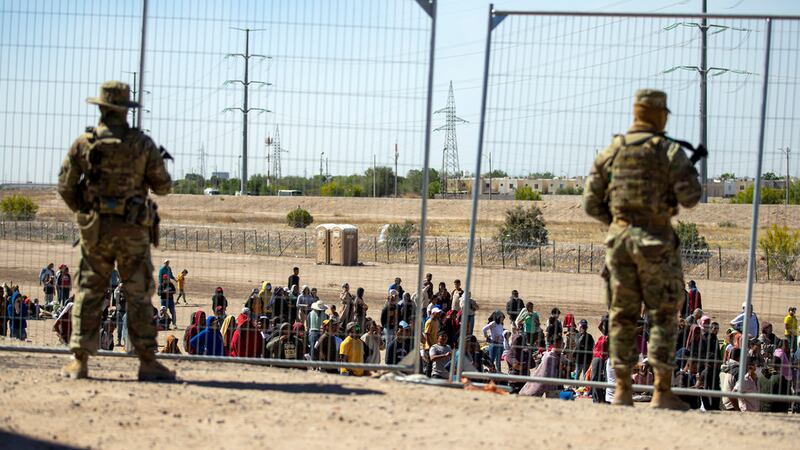 ARCHIVO - Gran cantidad de migrantes aguardan el miércoles 10 de mayo de 2023 junto a la cerca...