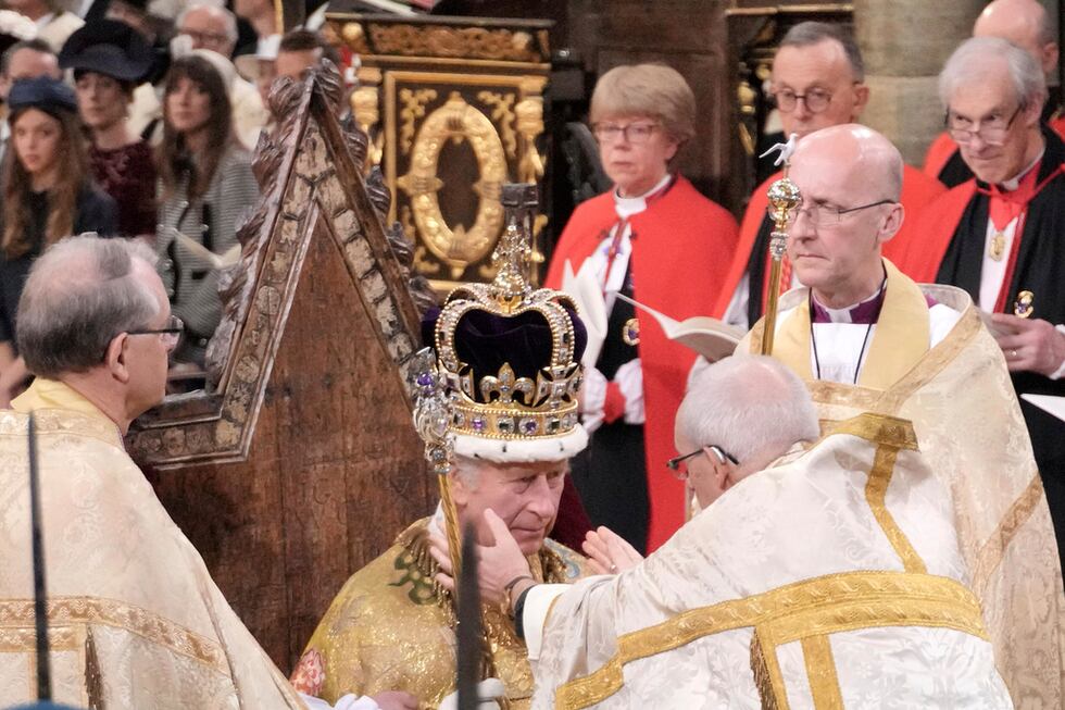 El rey Carlos III sentado mientras es coronado con la corona de San Eduardo por el arzobispo...