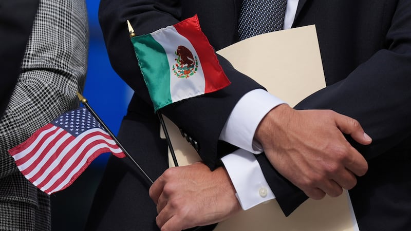 ARCHIVO – Una persona sostiene las banderas estadounidense y mexicana en una conferencia de...