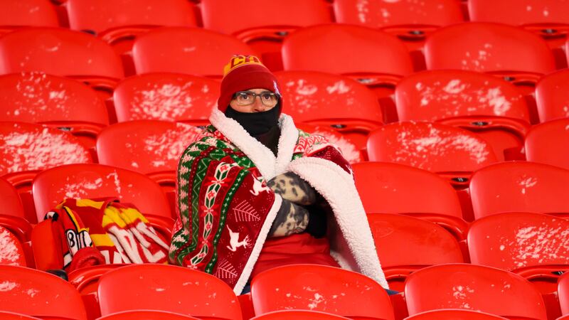 A Kansas City Chiefs fan is bundled up while watching warmups before an NFL wild-card playoff...