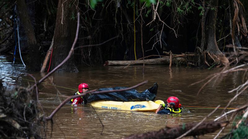 Bomberos de Ciudad Acuña, México, transportan un cuerpo que recuperaron en el río Guadalupe,...