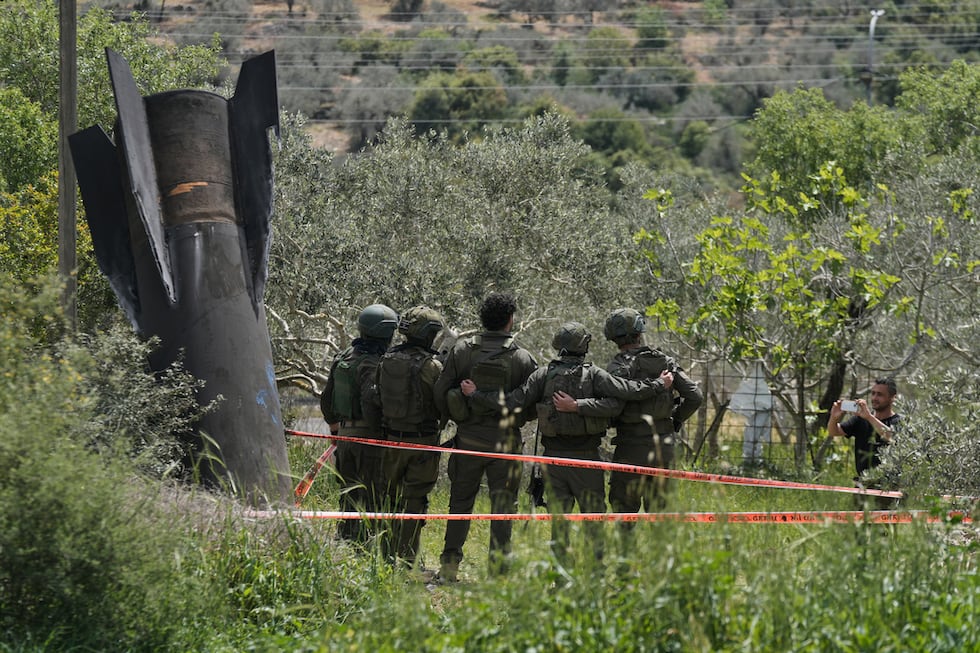 Soldados israelíes se toman una foto frente a los restos de un misil iraní que cayó el martes...