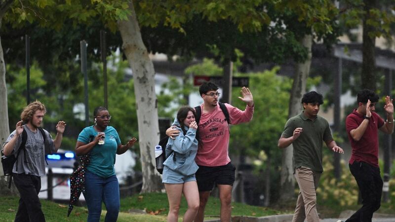 Estudiantes y empleados de la Universidad de Arkansas evacúan y se resguardan el lunes 25 de...