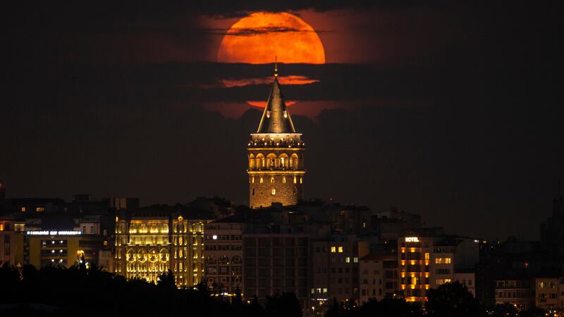 A supermoon rises behind the Galata Tower in Turkey. It is also called a strawberry moon...