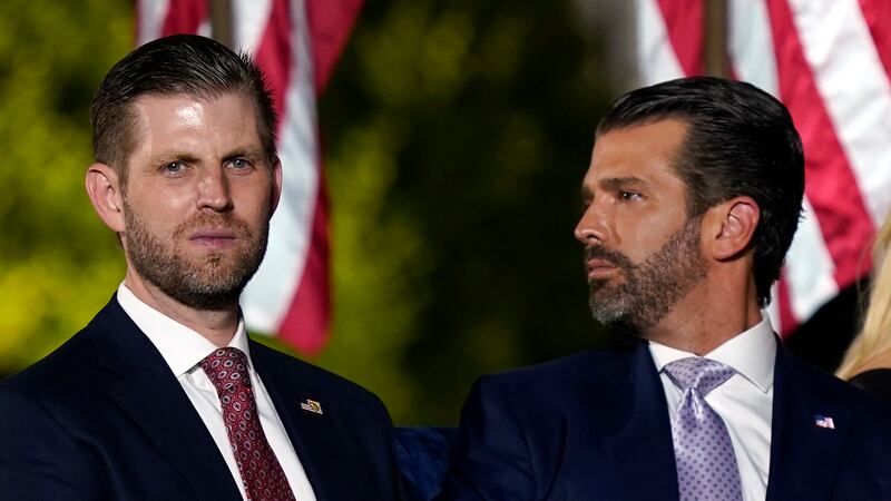 Eric Trump, a la izquierda, y Donald Trump Jr., esperan a que el presidente Donald Trump haga...