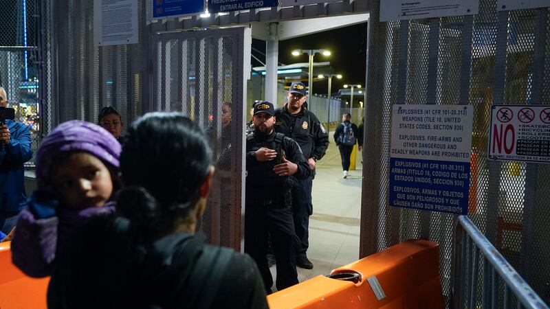 La guatemalteca Paula, en primer plano, carga a su hija mientras pregunta a agentes de la...