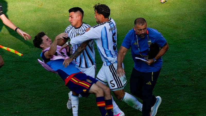 El centrocampista español Gavi cae el piso en medio de una pelea con los argentinos Leandro...