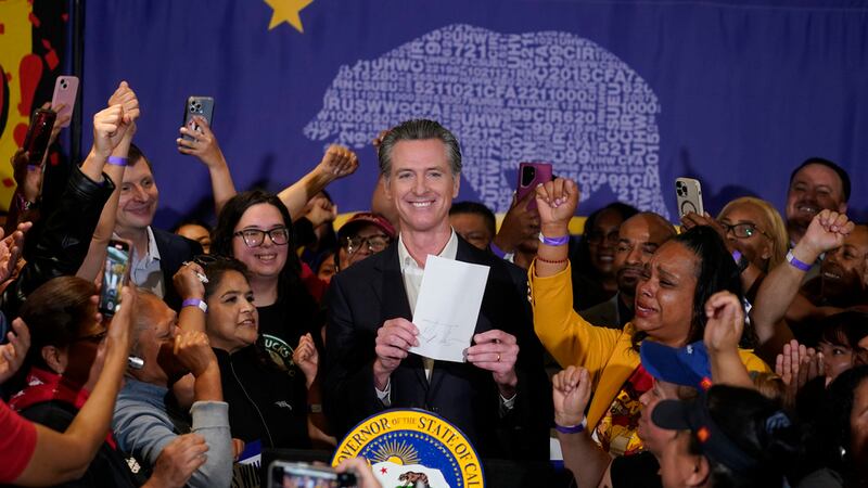 El gobernador de California, Gavin Newsom, muestra que ha firmado un proyecto de ley sobre...