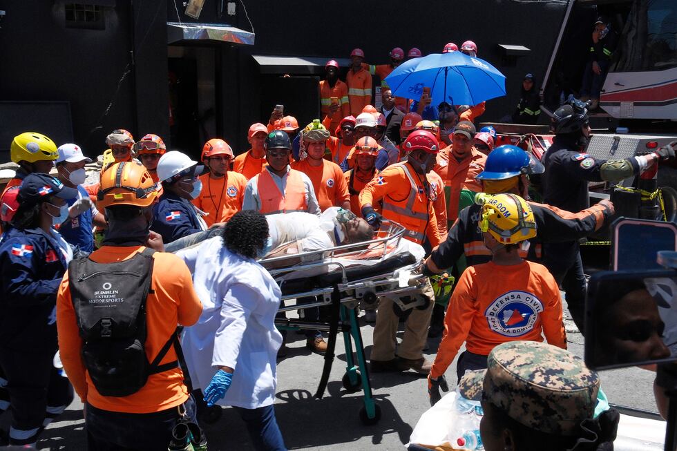 Rescatistas llevan a una persona sacada de entre los escombros del club nocturno Jet Set...