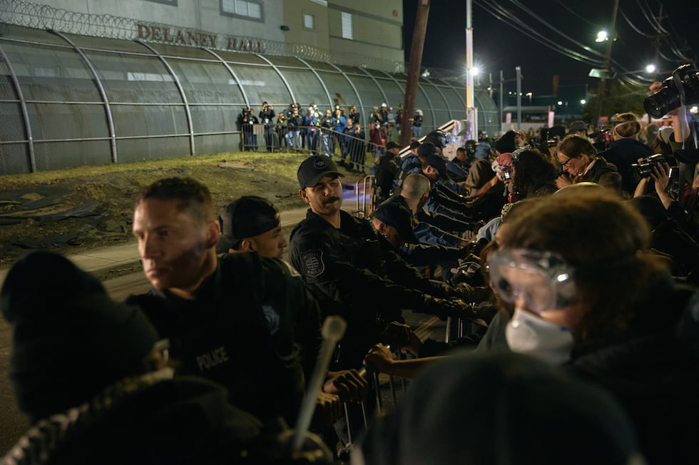 ARCHIVO - La policía intenta contener a los manifestantes que empujan las vallas frente al...