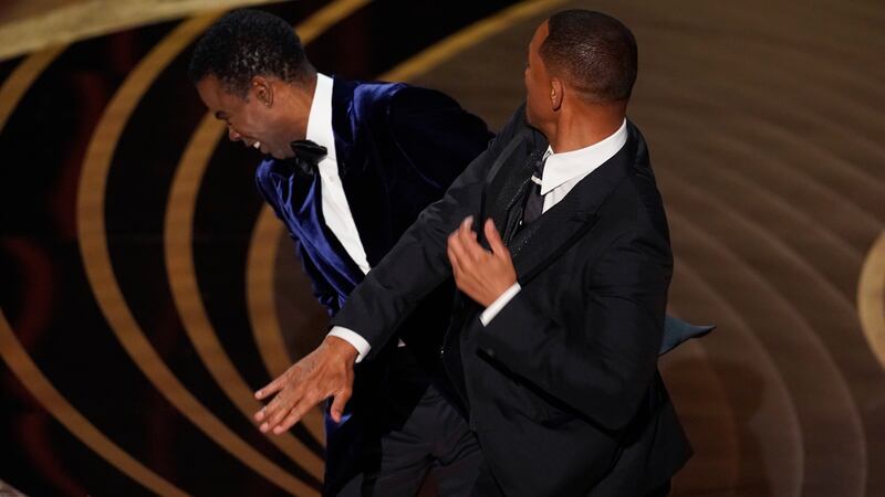 ARCHIVO - Will Smith, a la derecha, golpea al presentador Chris Rock en el escenario mientras...