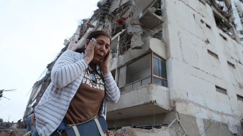 Una mujer pasa junto a un edificio dañado durante un terremoto en La Guaira, Venezuela, el...
