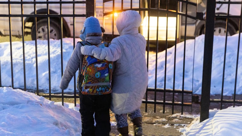 Giancarlo, de 10, es escoltado por su madre hasta la entrada de su casa para subir al bus...