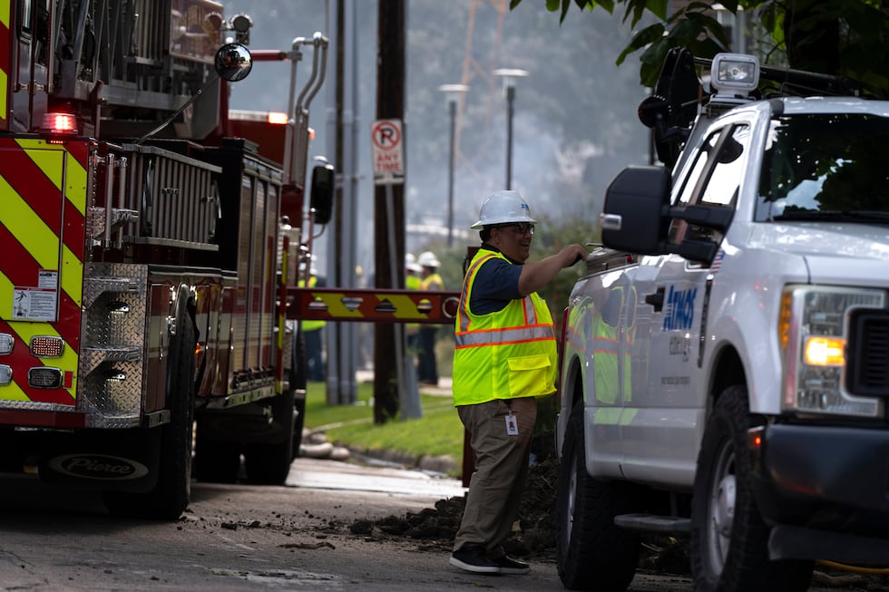 Un empleado de Atmos Energy trabaja en el lugar de un incendio en un complejo de apartamentos...
