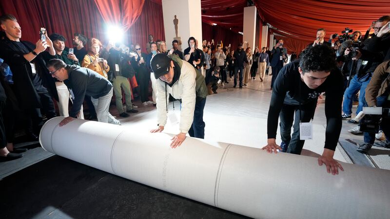 Trabajadores desenrollan la alfombra durante los preparativos para la 95a edición de los...